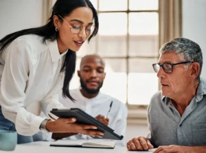 Insurance advisor presenting plan options to senior man during Medicare consultation