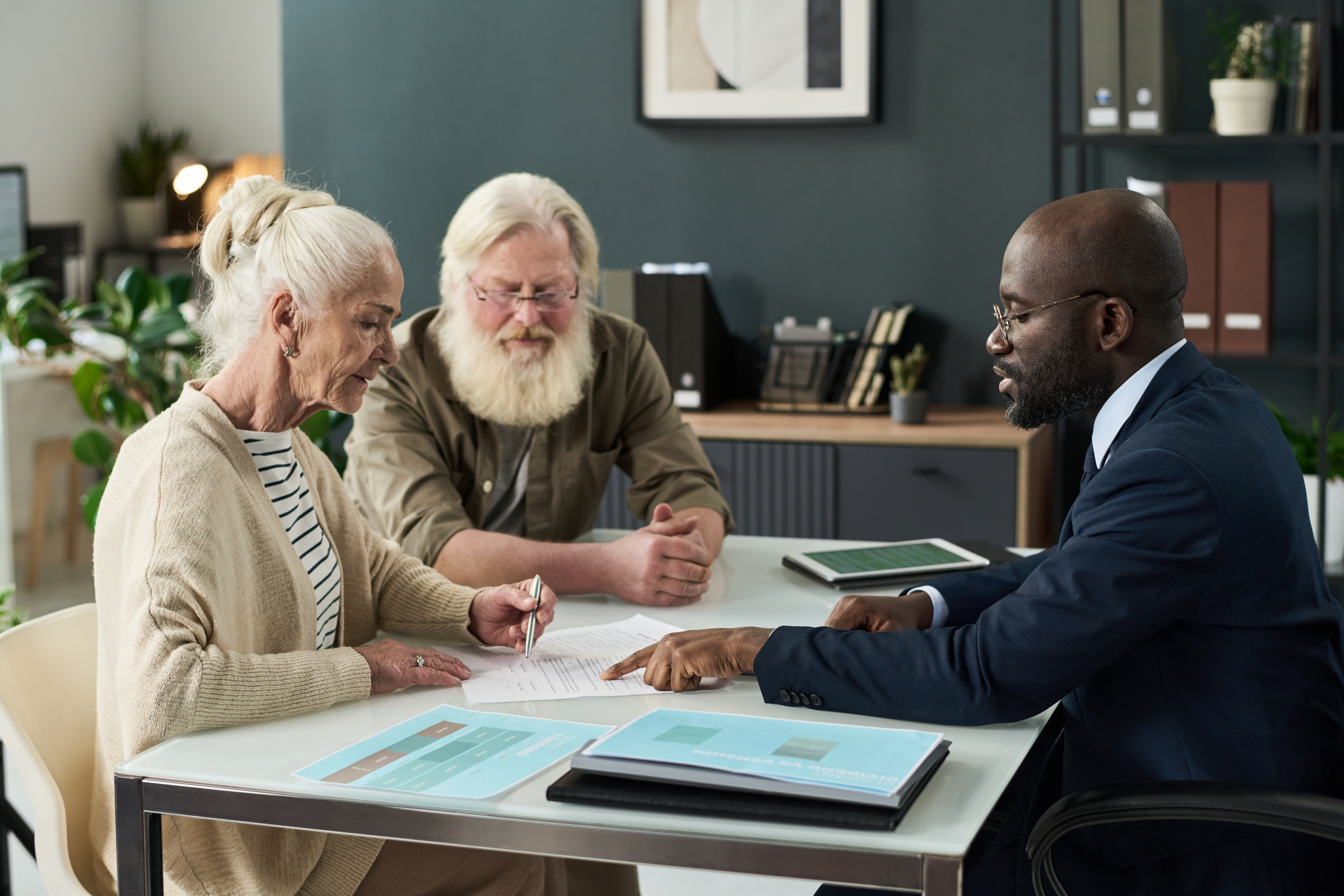 Senior woman signing Medicare-related paperwork during a review