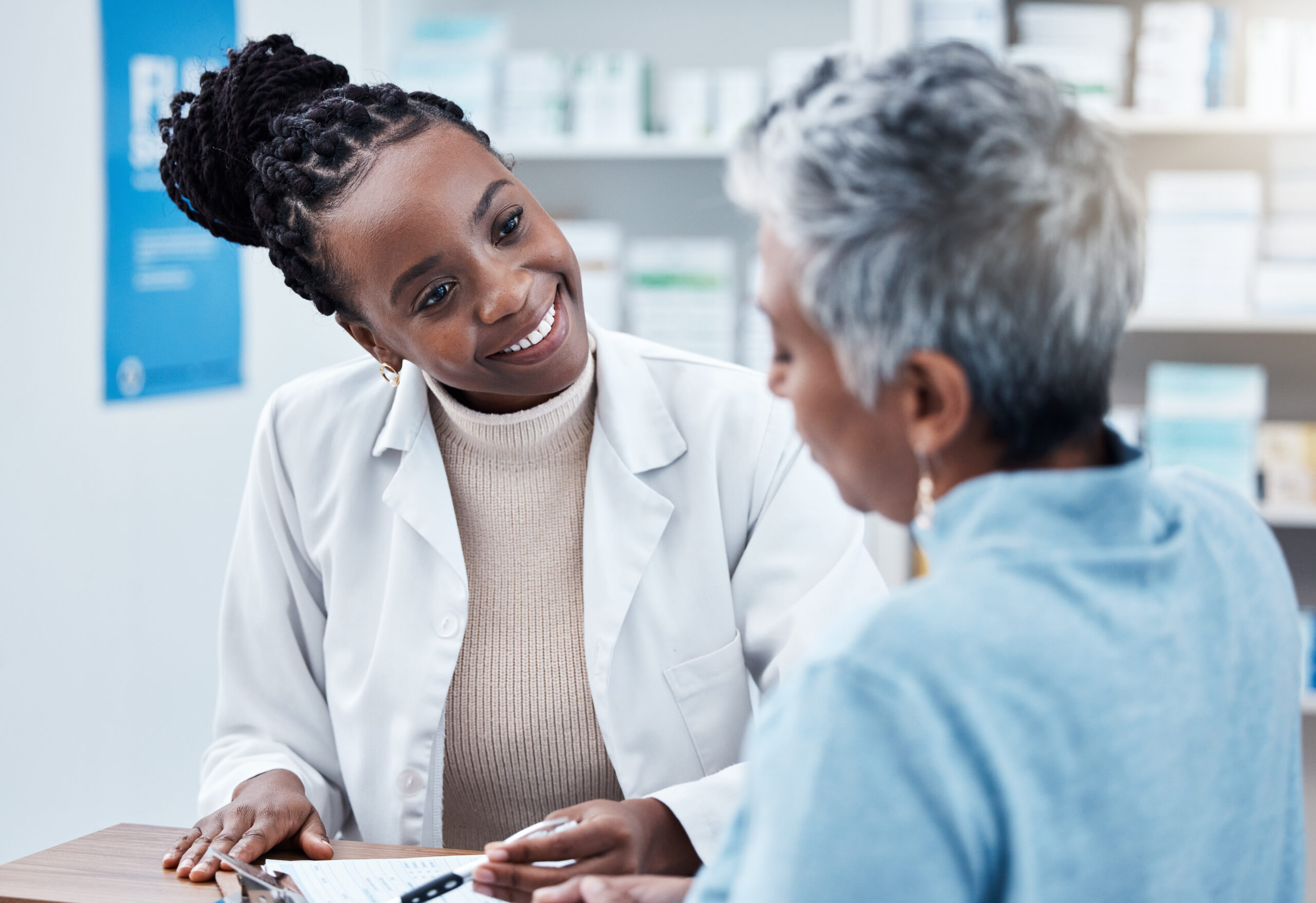 Customer speaking with a pharmacist about prescription coverage